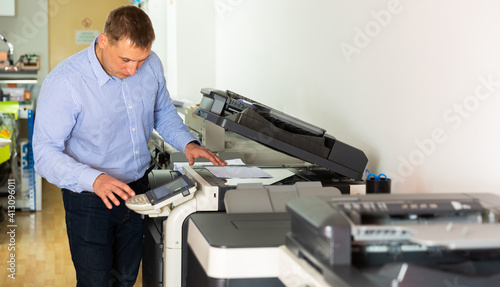 Worker is printing a file, document in the office room. High quality photo