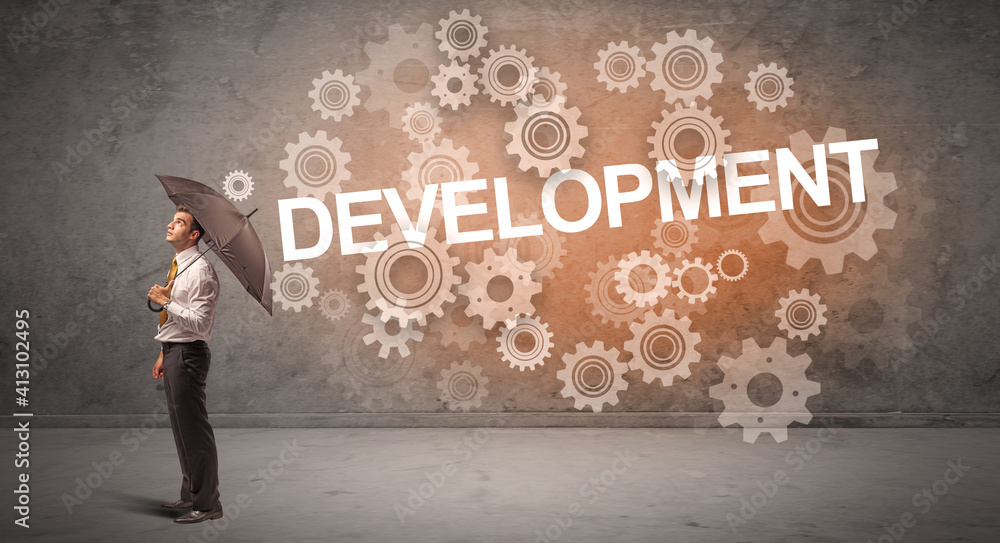 Businessman defending with umbrella from DEVELOPMENT inscription, technology concept Businessman defending with umbrella from DEVELOPMENT inscription, technology concept