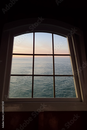 Sunset view of the ocean through a ship window
