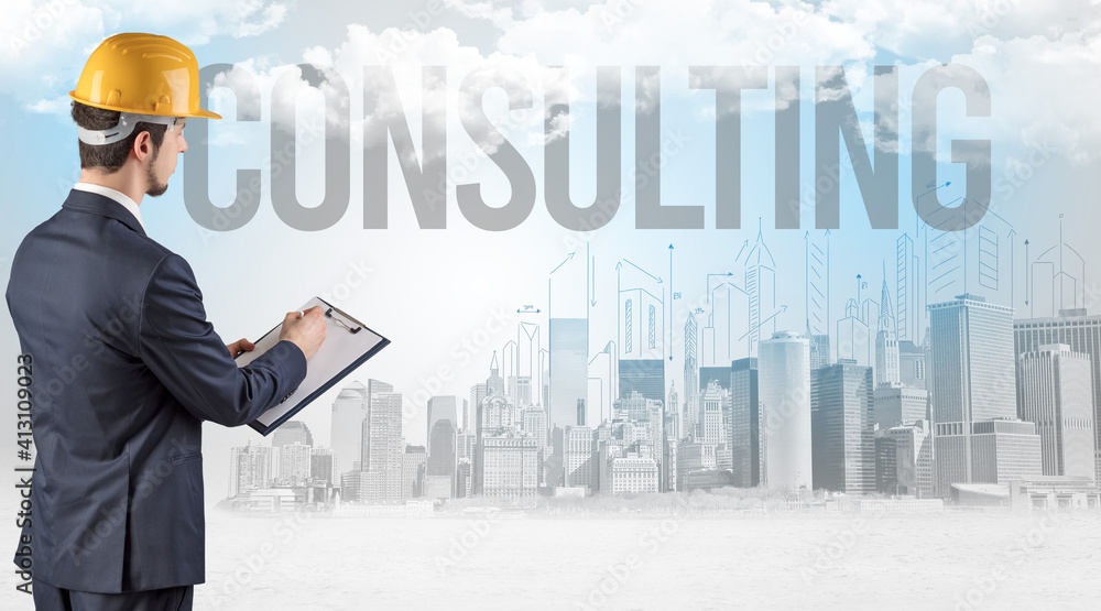 Young businessman with hard hat and CONSULTING inscription, new business opportunity concept Young businessman with hard hat and CONSULTING inscription, new business opportunity concept