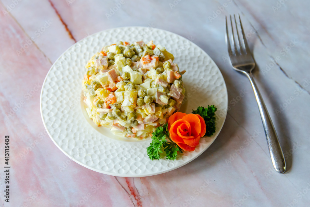 Traditional Russian festive salad Olivier (winter salad) on a white plate. Traditional Russian festive salad Olivier (winter salad) on a white plate.