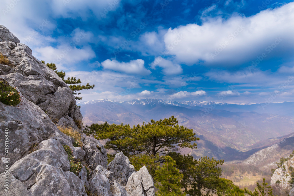 Beautiful scenery in the mountains with sharp limestome rocks, hiking path and April sky and showers, with cumulus clouds Beautiful scenery in the mountains with sharp limestome rocks, hiking path and April sky and showers, with cumulus clouds