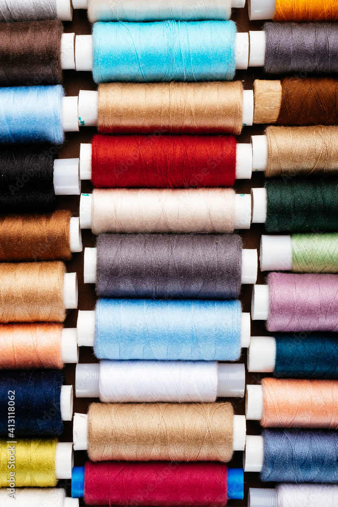Many different reels with threads, flat lay, top view. Colored threads, close-up, bright background. Cutting and sewing clothes concept. Accessories for needlework Many different reels with threads, flat lay, top view. Colored threads, close-up, bright background. Cutting and sewing clothes concept. Accessories for needlework
