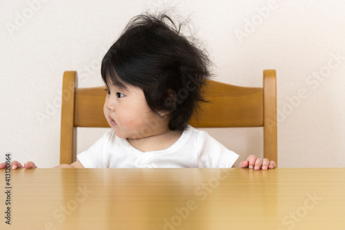 テーブルに座って、よそ見をする赤ちゃん（0歳、生後7か月、女の子、日本人）