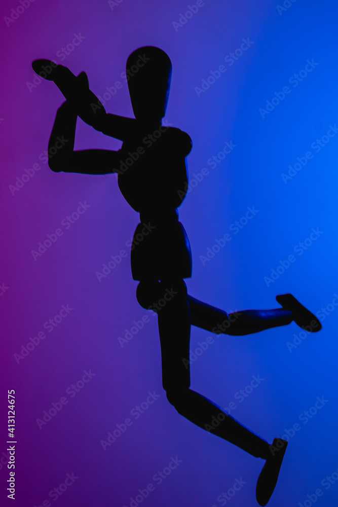 Silhoutte of a Doll dancing with on a blue and purple background