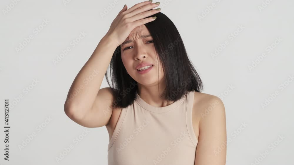 Portrait of upset Asian girl looking perplexed forget about something over white background. Face palm expression Portrait of upset Asian girl looking perplexed forget about something over white background. Face palm expression