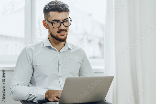 Businessman sitting in wheelchair and using laptop