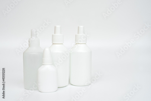 White plastic bottles of medicines on neutral background