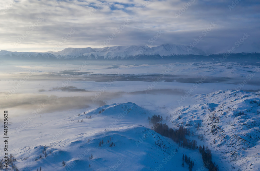 Aerial view of misty Kuray steppe in winter. Altai Republic, Siberia, Russia..
