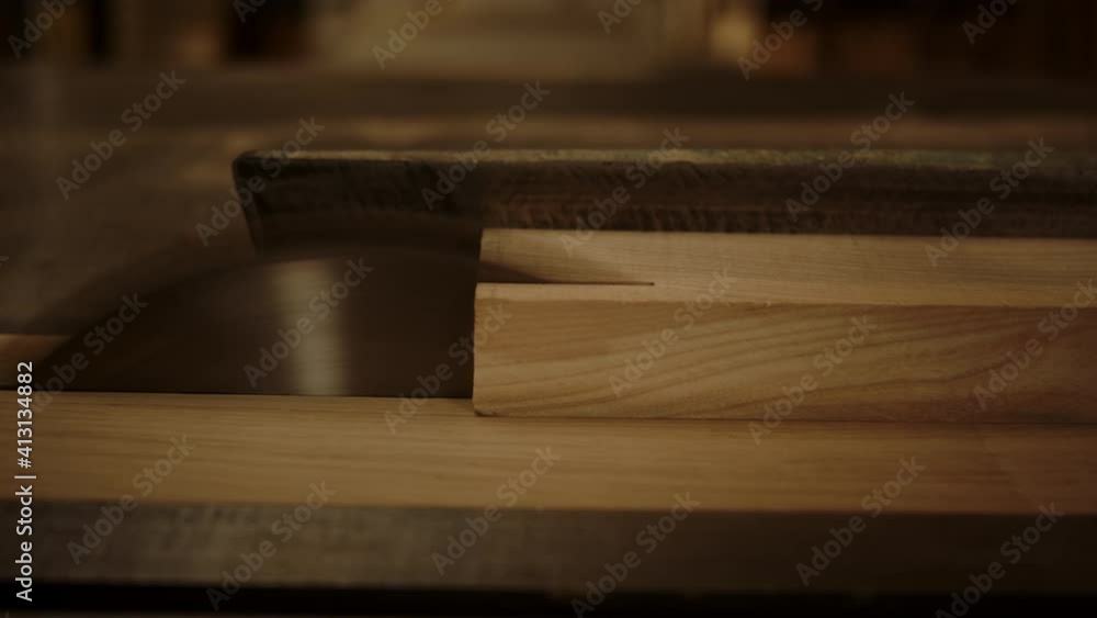 Unrecognized guy cutting wood indoors. Guy working with saw machine in studio Unrecognized guy cutting wood indoors. Guy working with saw machine in studio