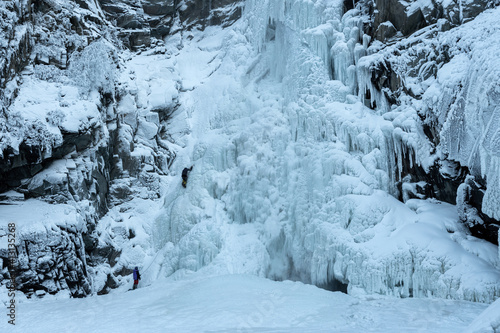 Ice climbers on frozen Kurkure waterfall (icefall). Chulyshman river valley, Altai Republic, Russia.