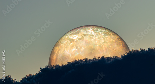 A bright moon in the snow made of soap bubbles.