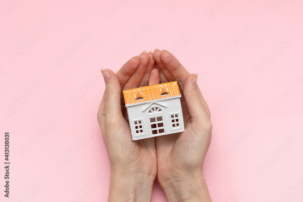 Female hand holding toys model house. Mortgage, safety and insurance concept by house in hand. Female hand holding toys model house. Mortgage, safety and insurance concept by house in hand.