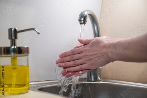 Washing hands with soap. woman washing hands with soap over the sink in the bathroom, close-up. Covid-19. Coronavirus: Cleaning hands.