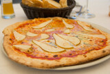 Big Italian pizza with fresh pears, tomato sauce and Gorgonzola blue cheese
