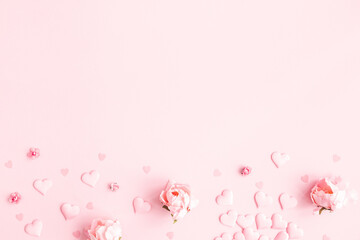 Valentine's Day background. Frame made of pink flowers, hearts on pastel pink background. Valentines day concept. Flat lay, top view, copy space