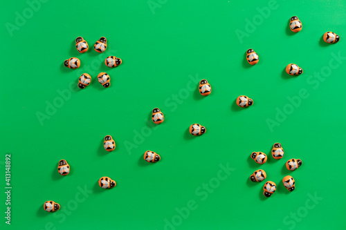 a pattern of orange wooden bees on green background