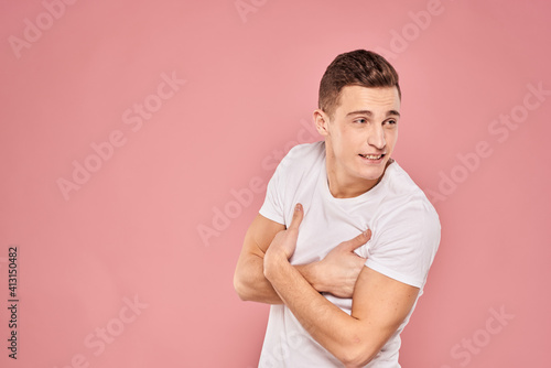 Emotional man gesturing with his hands white t-shirt pink isolated background