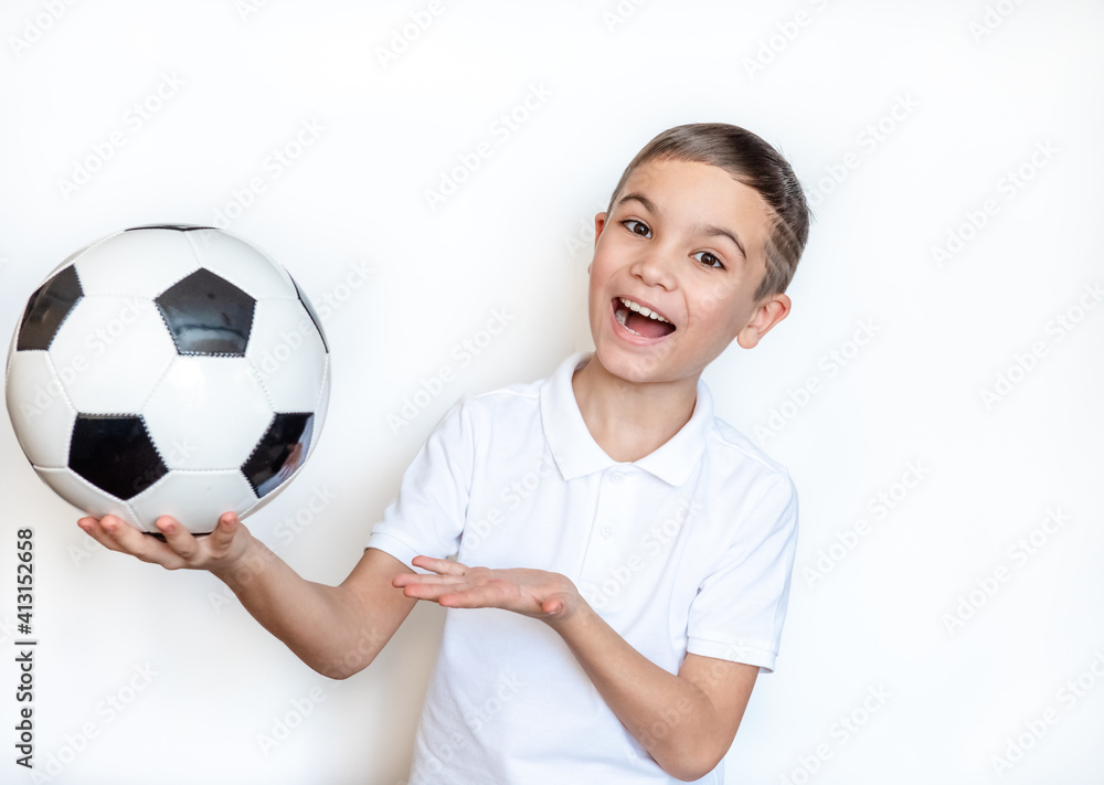 Portrait of an emotional child Boy holding a soccer ball in his hand. Boy in a white T-shirt on a white background. Looking at camera. Place for text. Portrait of an emotional child Boy holding a soccer ball in his hand. Boy in a white T-shirt on a white background. Looking at camera. Place for text.