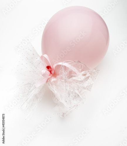 Pink balloon with delicate white bows. Isolated on white background.