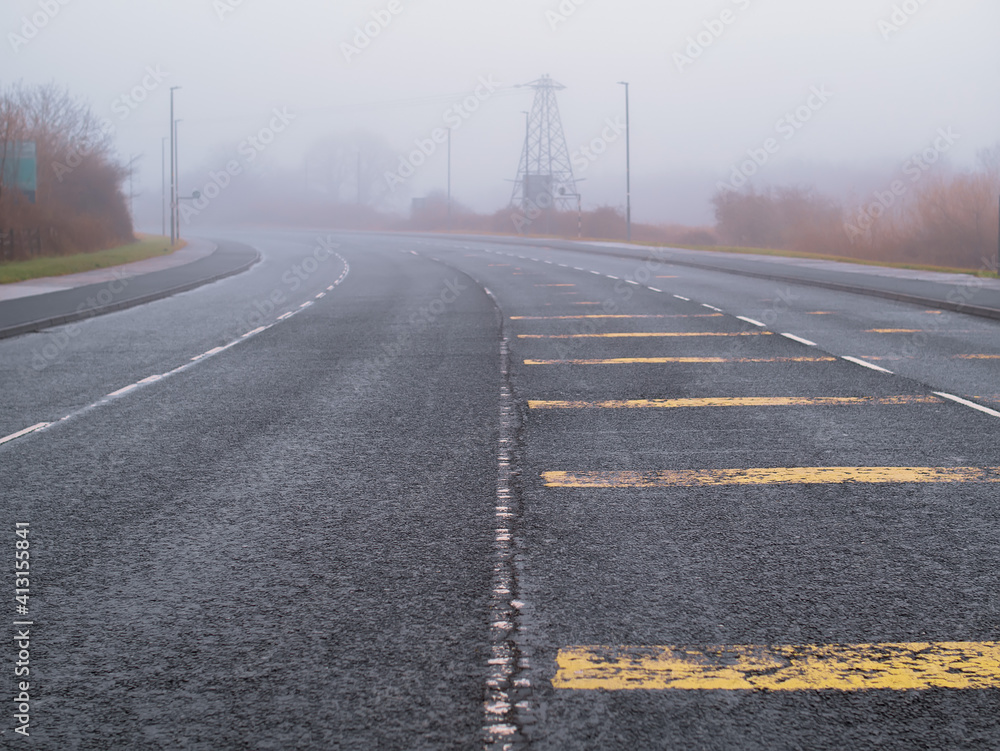 Fototapeta premium Empty asphalt road in town in a fog. Mist over town traffic. Dangerous conditions. Selective focus
