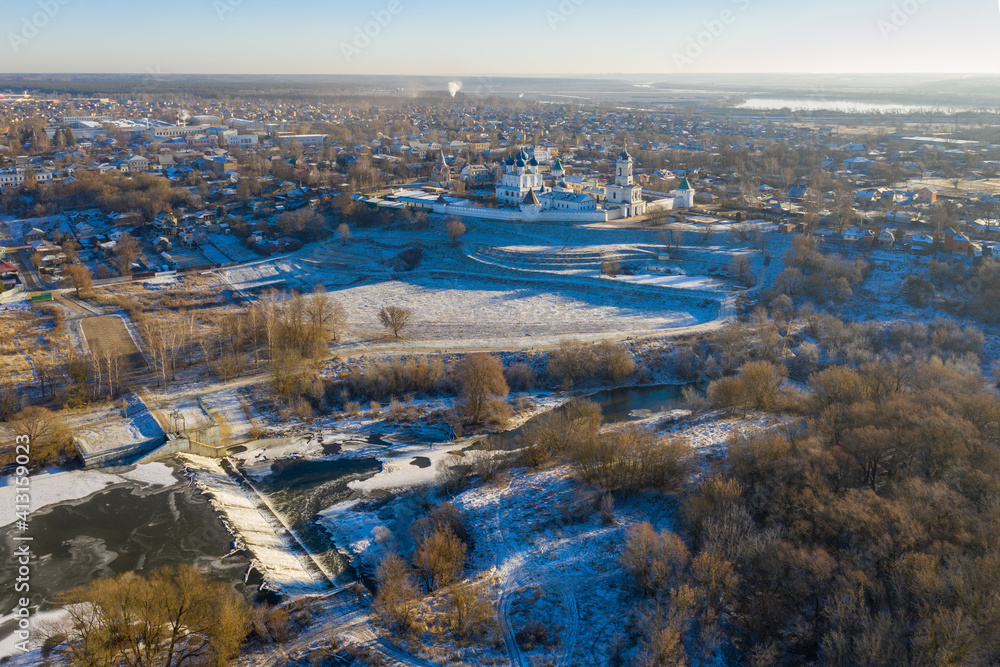 Aerial view of Vysotsky Zachatievsky (Immaculate Conception) monastery and dam on Nara river at sunny winter day. Serpukhov, Moscow Oblast, Russia.