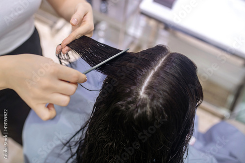 Close up picture of hair stylists hands cutting hair