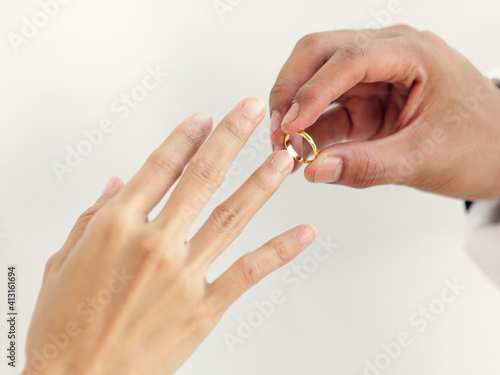 Man putting ring to woman finger, a symbol of love and married