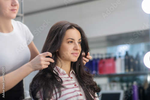 Female hairdresser looking involved while working with a client