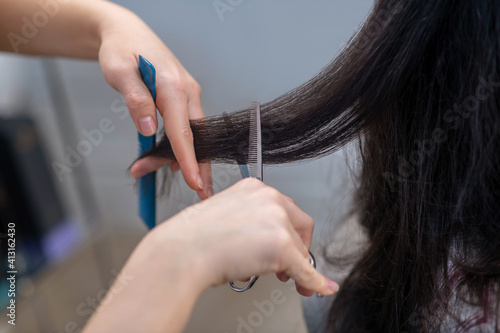 Close up picrture of hand of hairdresser during the haircutting process