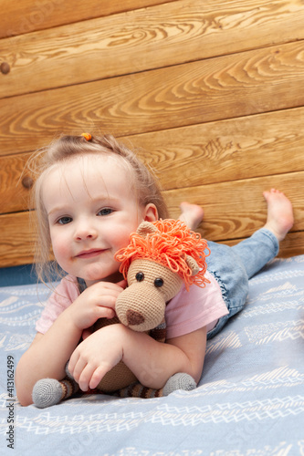 portrait of a cute little girl with a colorful stuffed toy