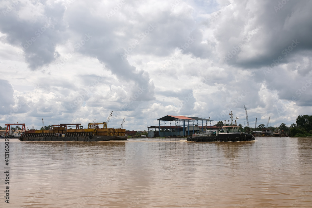 Sibu, Malaysia - February 12, 2021: The view outside a ferry and tug boat uses to transport containers.