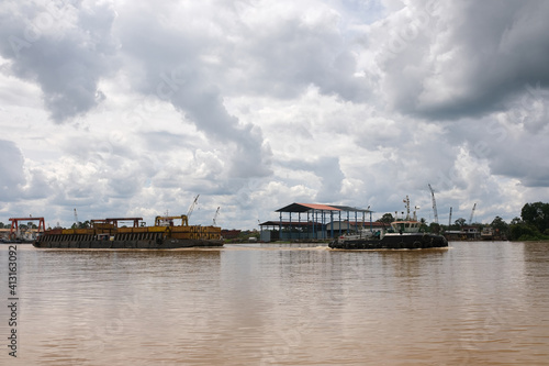 Sibu, Malaysia - February 12, 2021: The view outside a ferry and tug boat uses to transport containers. © AL
