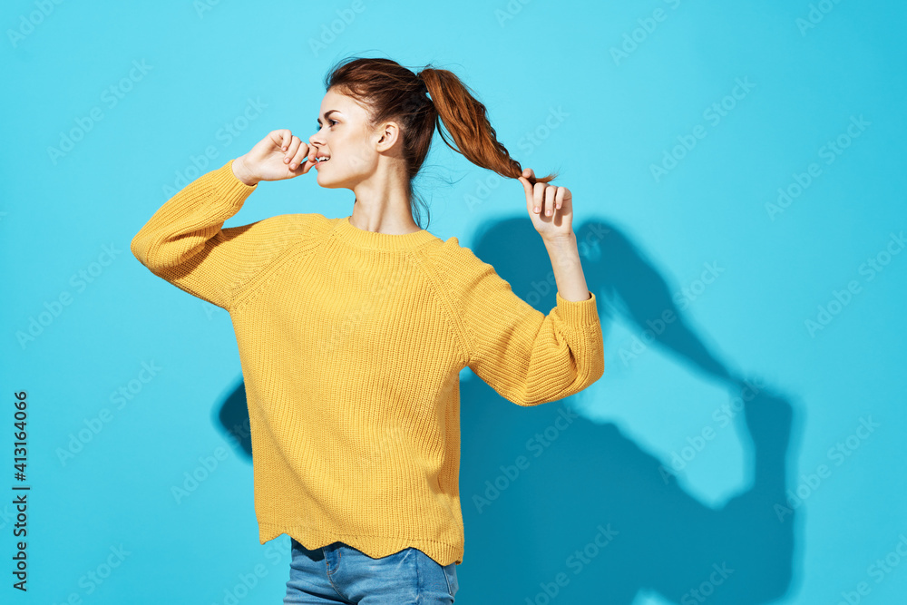 pretty woman in yellow sweater attractive look emotions close-up blue background pretty woman in yellow sweater attractive look emotions close-up blue background