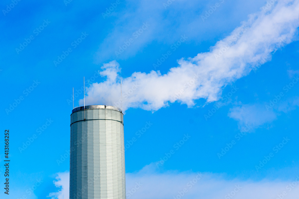 Obraz premium One Industrial smoke pipe from chimney on blue cloudy sky.