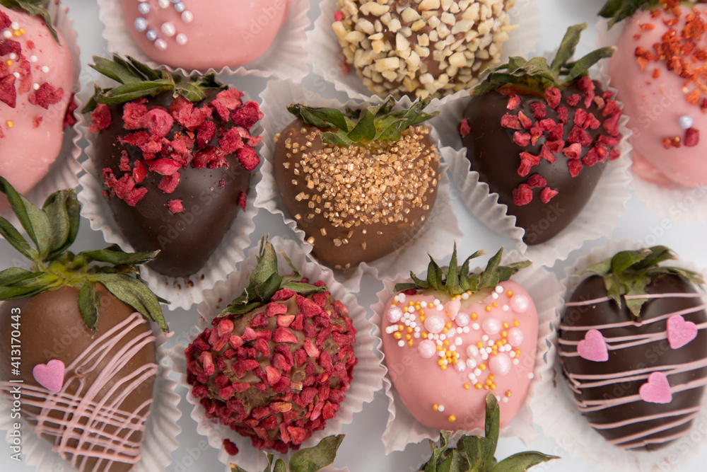 Naklejka premium Variety of strawberries covered with chocolate, dark and white chocolate and nuts, on a isoleted background