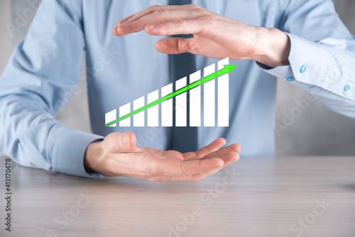 Businessman man holding a graph with positive profits growth. plan graph growth and increase of chart positive indicators in his business.more profitable and growing