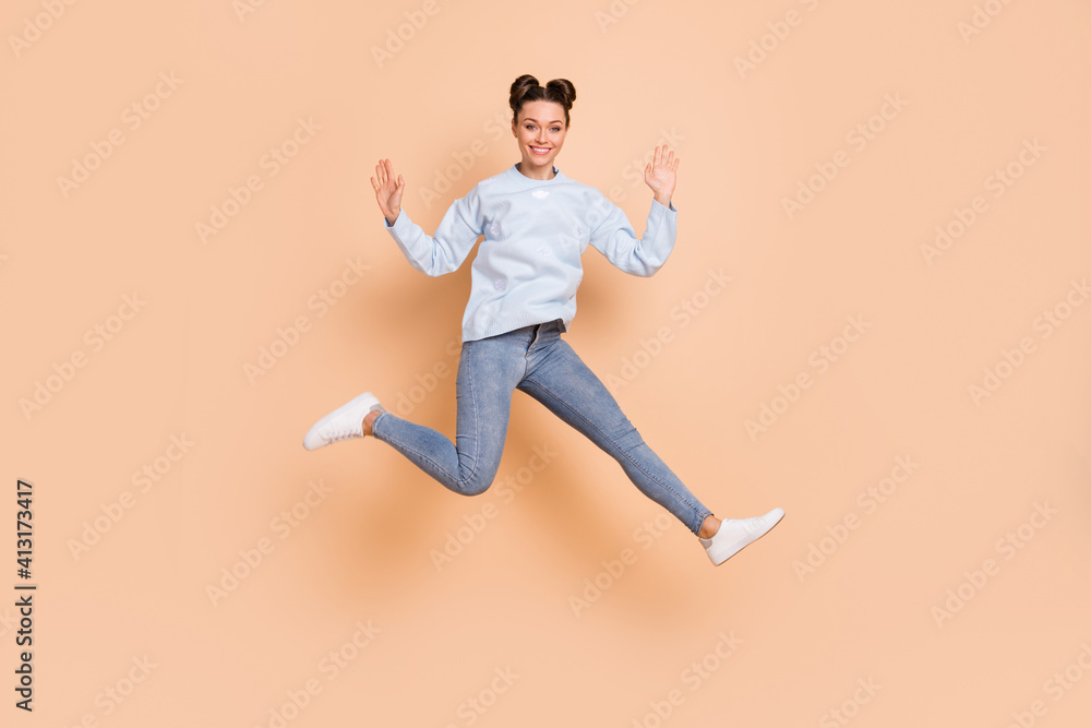 Full size profile photo of optimistic nice brunette lady jump run arms up wear blue sweater jeans sneakers isolated on beige background
