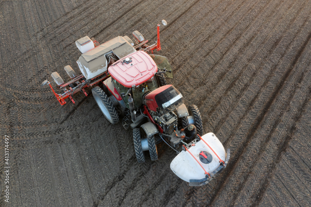 A modern tractor sows the field and applies soluble fertilizers and pesticides.