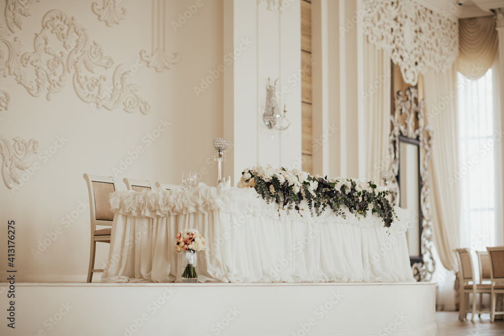 Luxurious, elegant wedding white table with floral centerpiece.