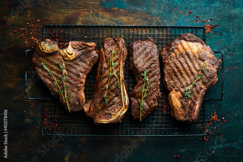 Set steaks on the grill: t-bone, striploin, Rib eye, new york steak. Top view. Rustic style.