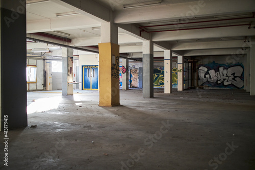 a grey and empty parking lot with writing on wall