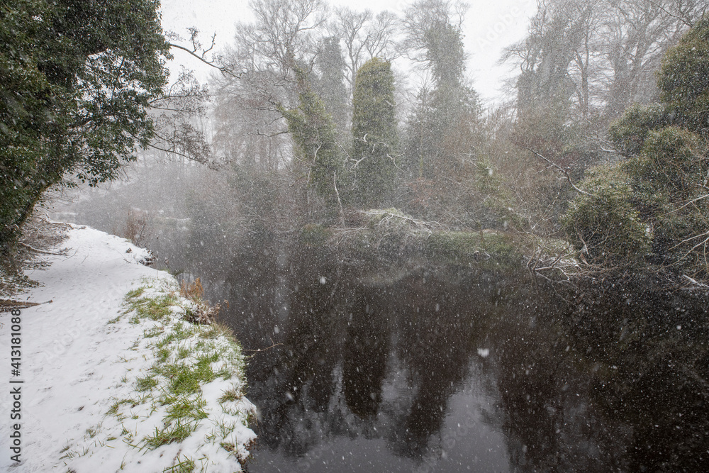 river, stream, during a snow storm, blizzard, in winter in scotland.