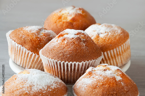Close-up of a muffin on the background of a plate with muffins, selective focus.