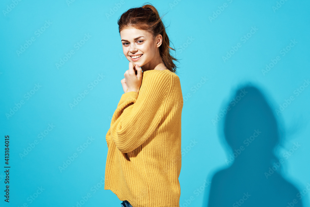 Fototapeta premium attractive woman in yellow sweater and jeans casual wear emotions posing blue background