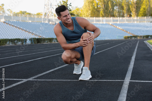 Man in sportswear having knee problems at stadium © New Africa