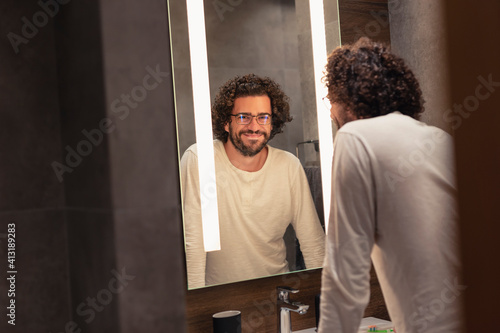 Man standing in front of bathroom mirror photo