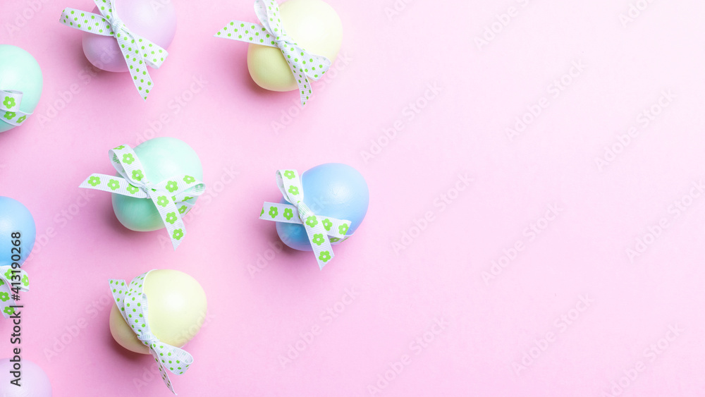 Easter holiday. Colourful egg with tape ribbon on pastel pink background in Happy Easter decoration. Spring holiday top view with copy space.
