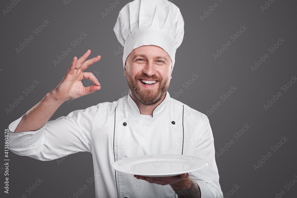 Friendly chef with plate gesturing OK Friendly chef with plate gesturing OK