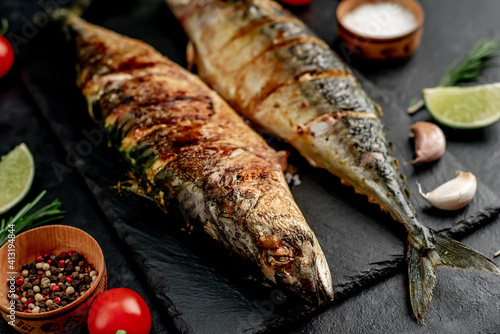 grilled mackerel with lime and spices on stone background